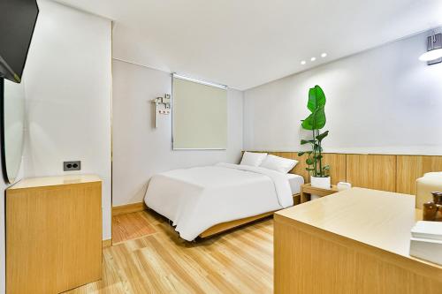 庆州Gyeongju Hotel Gonggan的一间带白色床的卧室和一间厨房