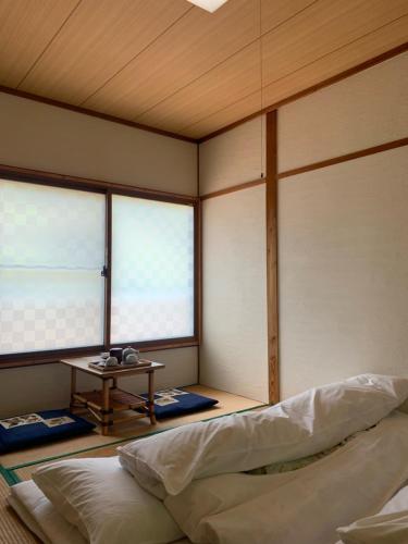 三好市Iya Kankou Ryokan的一个带一张床和一张桌子的房间的角落
