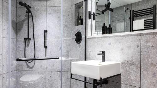 莱斯特voco Leicester, an IHG Hotel的浴室配有白色水槽和淋浴。