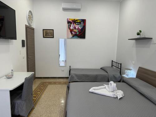 FicarazziGALAXY BED & PIZZA的客厅配有两张床,墙上挂有绘画作品