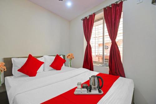 加尔各答GRG Vhyom Sky Palace Near Metro Station Kolkata的卧室配有带红色枕头的白色床