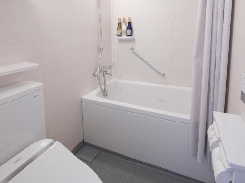 札幌Vessel Hotel Campana Susukino的白色的浴室设有浴缸和卫生间。