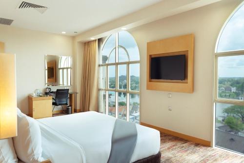 古晋古晋海滨酒店的酒店客房设有一张床和一个大窗户