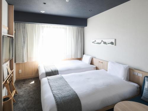 札幌Vessel Hotel Campana Susukino的酒店客房设有两张床和窗户。