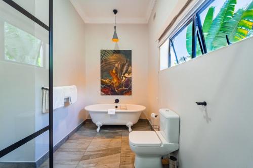 维多利亚瀑布Nkosi Guest Lodge的带浴缸和卫生间的浴室。
