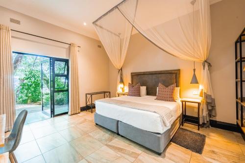 维多利亚瀑布Nkosi Guest Lodge的一间卧室设有一张床和一个大窗户