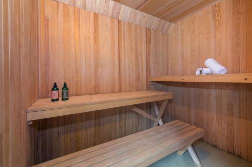 Le TourChalet La Remuaz - Happy Rentals的一间提供两瓶酒精饮品的桑拿浴室和一张长凳