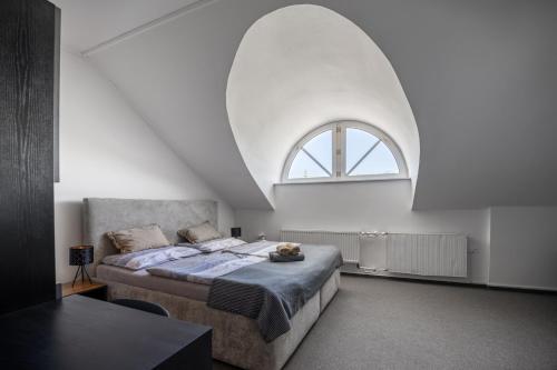 乌赫尔布罗德Hotel & SPA centrum PALMIRA的一间卧室设有一张大床和一个拱形窗户