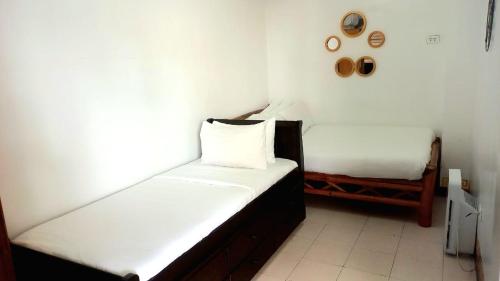 马比尼The Philip Ann Resort的配有白色墙壁的小客房内的两张床