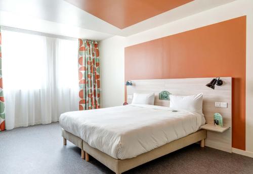 圣旺B&B HOME Paris Mairie de Saint-Ouen的一间卧室配有一张带橙色墙壁的大床