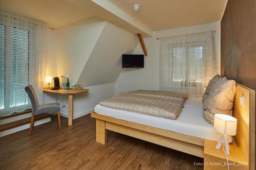 新明斯特Hotel aanders的一间卧室配有一张床和一张桌子及椅子