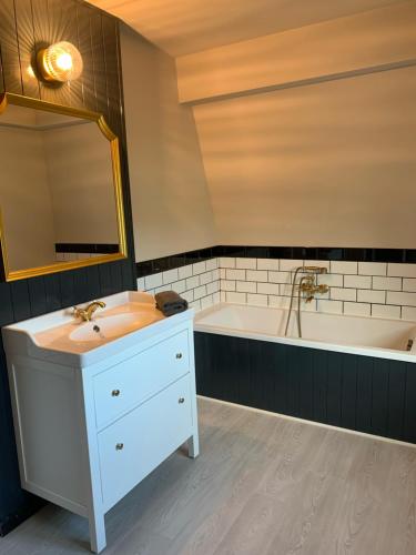 米德尔克尔克Villa La Dune - Ontbijt & parking inclusief的浴室配有盥洗盆和浴缸。