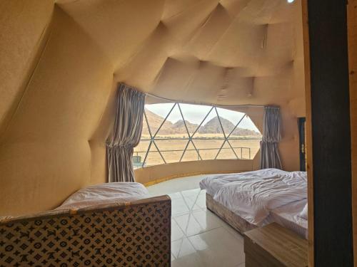 瓦迪拉姆Salma Desert Camp的带大窗户的客房内的两张床