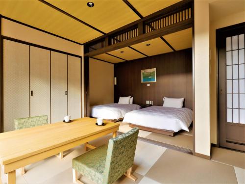 箱根Hotel Morinokaze Hakone Sengokuhara的一间卧室配有两张床和一张桌子及椅子