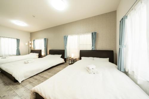 武藏野23, Midoricho, Entire house, Capacity 6 people的配有白色床单的客房内的两张床