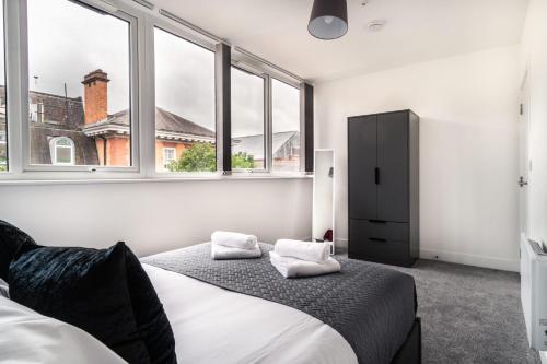 雷克瑟姆Modern 1 Bed Apartment in Central Wrexham的一间卧室设有两张床和两个窗户。