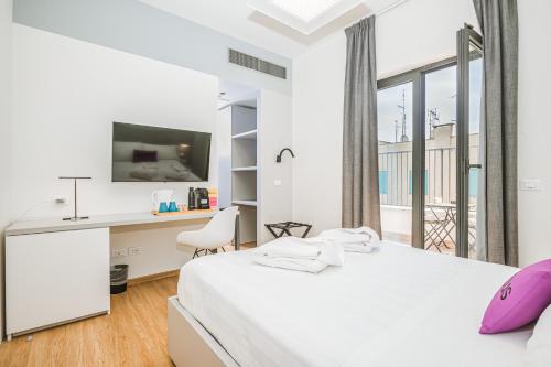 罗马Dotcampus Roma City Center的白色卧室设有床、书桌和窗户