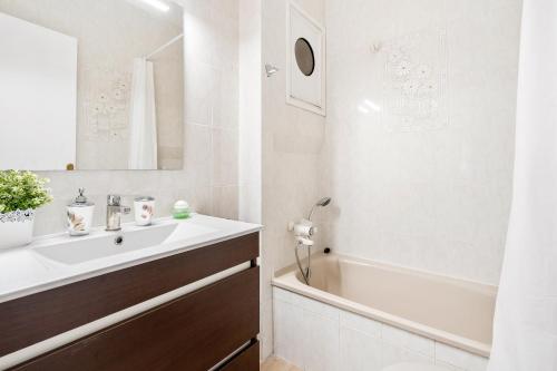 滨海比拉萨尔Barcelona coast apartment - only 5 minutes to the beach的白色的浴室设有水槽和浴缸。