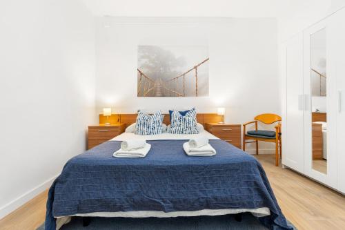 滨海比拉萨尔Barcelona coast apartment - only 5 minutes to the beach的卧室配有蓝色的床,墙上设有桥梁