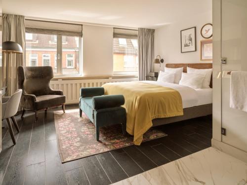 汉堡The Nikolai Hamburg - Leonardo Limited Edition的配有一张床和一把椅子的酒店客房