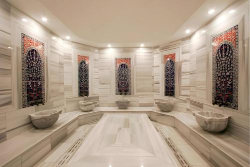 伊斯坦布尔Byotell Hotel Istanbul的大堂设有3个水槽和彩色玻璃窗