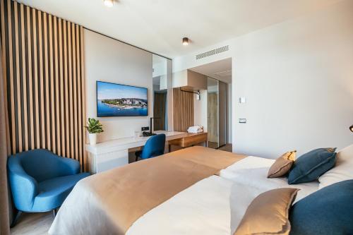 波尔托罗里维埃拉莱夫库拉斯酒店 - 温泉及健康中心的一间卧室配有一张大床和蓝色的椅子