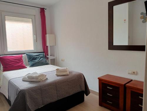 滨海罗克塔斯Primera Linea De Playa的一间卧室配有一张带镜子和梳妆台的床