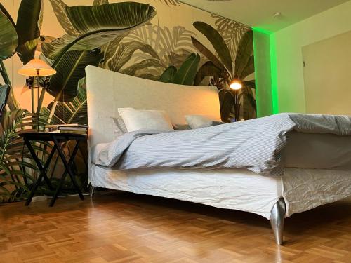 菲尔德施塔特Designerwohnung nahe Stuttgart Messe und Flughafen的一间卧室配有白色床单和植物床