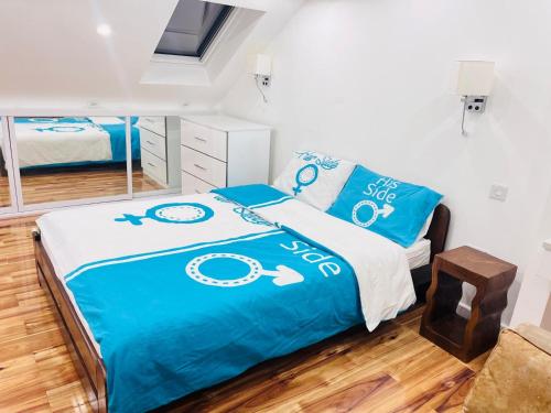 埃德蒙顿Private Room的一间卧室配有一张带蓝色床单和镜子的床
