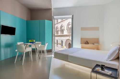 特拉帕尼Fiveplace Design Suites & Apartments的一间卧室配有一张床和一张桌子及椅子