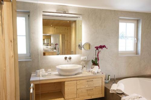 罗登戈Hotel Schönblick的一间带水槽和大镜子的浴室
