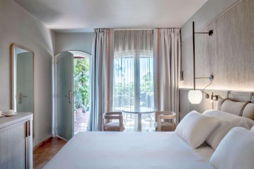 奇亚Veridia Resort Sardinia, a member of Radisson Individuals的卧室配有一张白色的大床和一张桌子