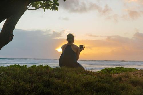 利胡埃OUTRIGGER Kaua'i Beach Resort & Spa的坐在海滩上拍着海洋照片的女人