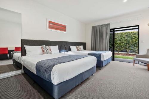 洛坎普顿Quality Resort Parkhurst的酒店客房设有两张床和窗户。