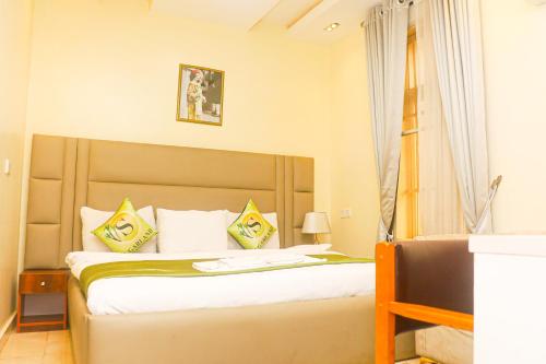 伊凯贾Sugarland Hotel and Suite的一间卧室配有黄色和白色枕头的床