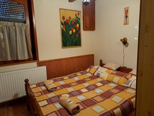 波罗斯洛Pásztor Vendégház的卧室内的两张床,墙上有绘画作品