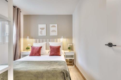 马德里Metropolitano en Madrid的一间卧室配有一张大床和两个红色枕头