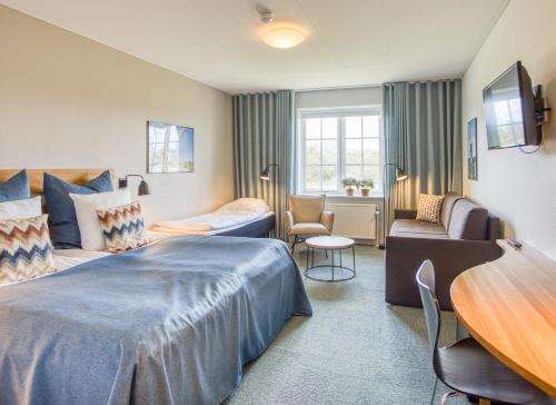 斯卡恩斯盖恩七彩酒店的酒店客房配有床、沙发和桌子。