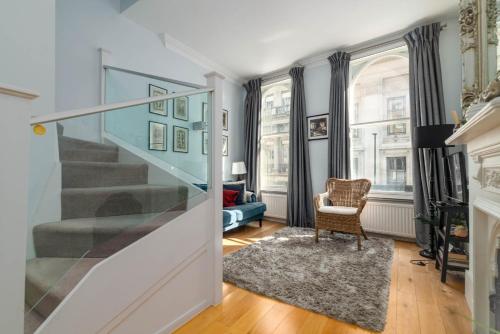 伦敦GuestReady - Stunning Covent Garden 2BR Duplex的一间带楼梯和椅子的客厅