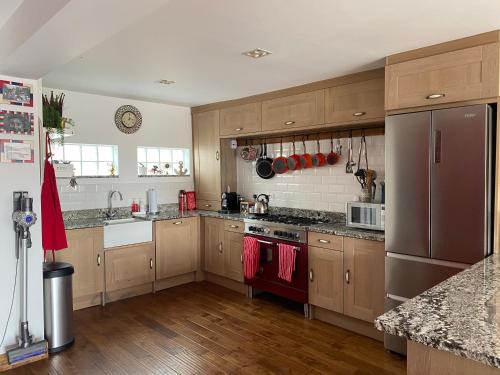 泰恩河畔纽卡斯尔Marina View的厨房配有木制橱柜和不锈钢冰箱。