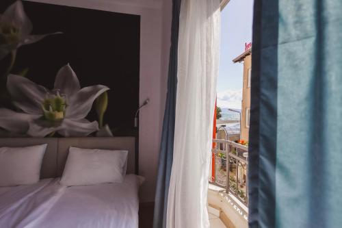 奥赫里德AMMOTTI Hotel and Apartments的一间卧室设有一张床,享有阳台的景色