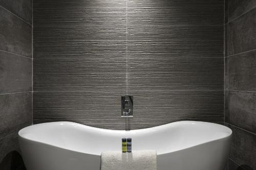 巴利科顿湾景酒店的带浴缸的浴室和灰色的墙壁