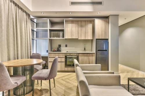 开普敦WINK Aparthotel One Thibault的厨房以及带桌椅的用餐室。