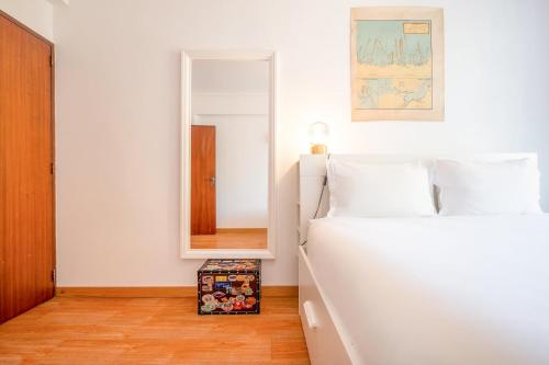 卡帕里卡海岸GuestReady - Salty Retreat in Trafaria的卧室配有白色的床和镜子