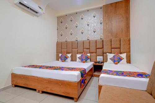 乌贾因FabExpress SK Prime的一间卧室设有两张床和一堵墙