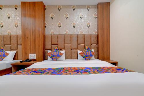 乌贾因FabExpress SK Prime的卧室配有一张带彩色枕头的大型白色床。