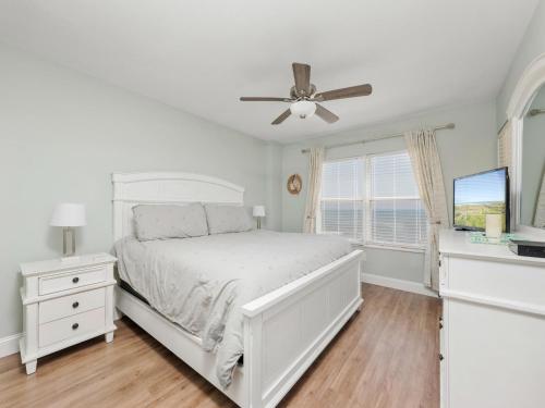 奥蒙德海滩Sea Winds 501 - Corner Breeze的白色卧室配有床和吊扇