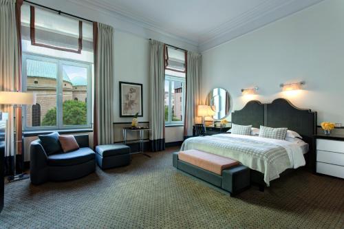 柏林罗马罗科·福尔蒂酒店的一间卧室配有一张床、一把椅子和镜子