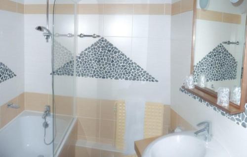 卢昂木林德布尔城堡酒店的带淋浴、盥洗盆和浴缸的浴室