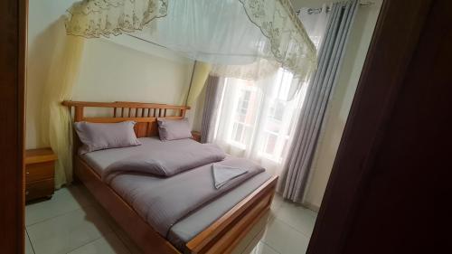 Room in Guest room - Charming Room in Kayove, Rwanda - Your Perfect Getaway的窗户客房内的小床